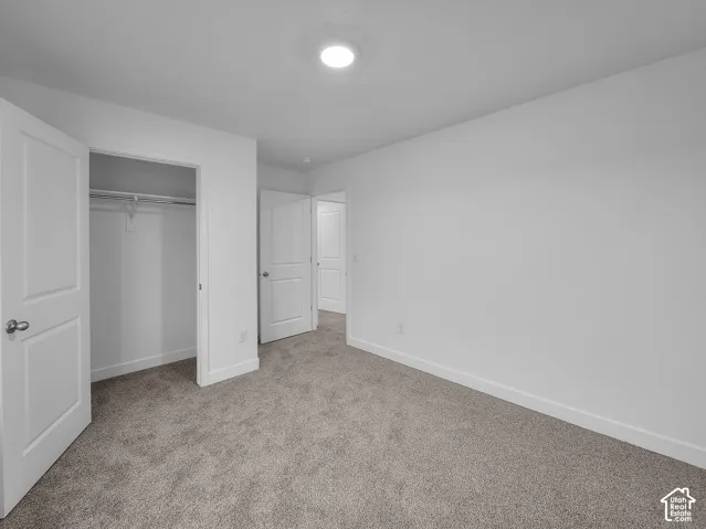 Plush carpeting, recessed lighting, and a built-in closet with hanging rod