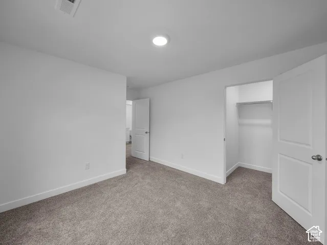 Plush carpet flooring, recessed ceiling lighting, a built-in closet with hanging rod, and white paneled doors