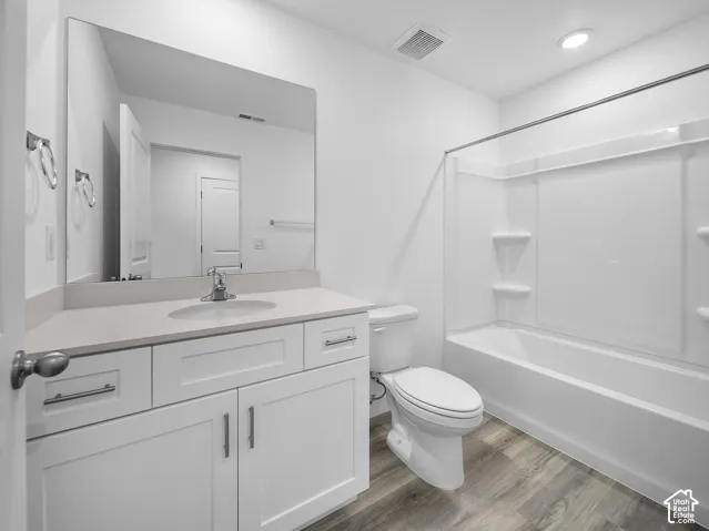 White vanity with shaker-style cabinetry, a single basin sink, and a large wall-mounted mirror