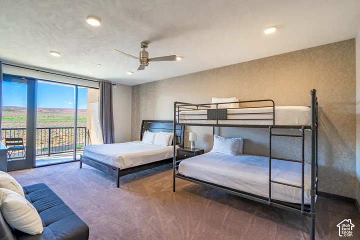 Sliding glass door to balcony, recessed lighting, ceiling fan, textured accent wall, and carpeting