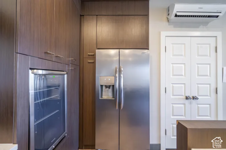 Built-in stainless steel refrigerator, stainless steel beverage cooler, and dark wood-finish cabinetry with silver-tone hardware