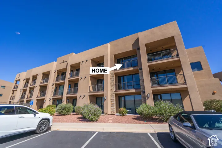 Multi-story building featuring stucco exterior, individual balconies with metal railings, and integrated stone accents