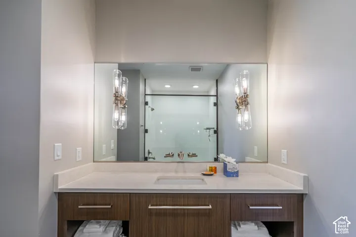 Built-in vanity with a light-colored countertop, integrated sink, and wood-finish cabinetry