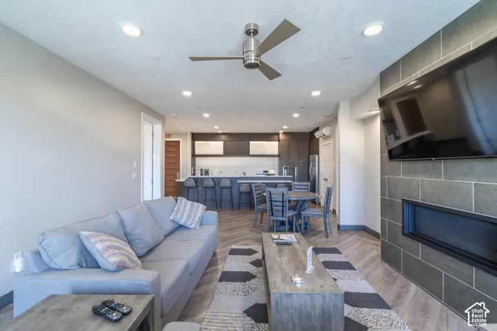 Open-concept living space featuring wood-finish flooring, recessed lighting, and a ceiling fan
