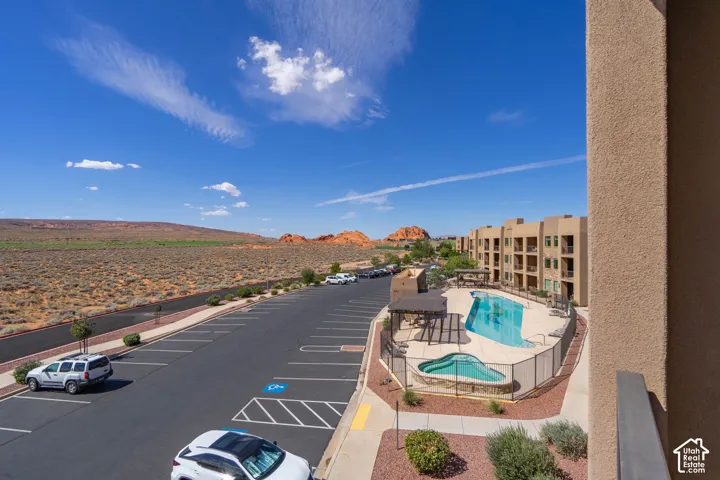 Outdoor pool and spa area with surrounding desert landscape and distant rock formations