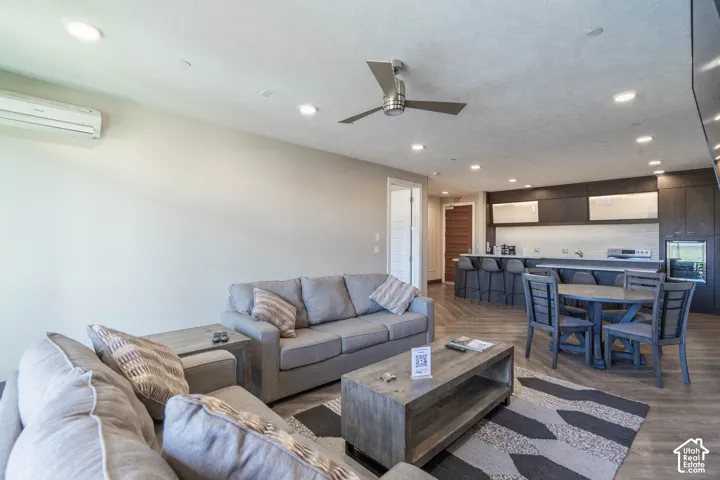 Open-concept living space featuring wood-finish flooring, recessed lighting, and a ceiling fan