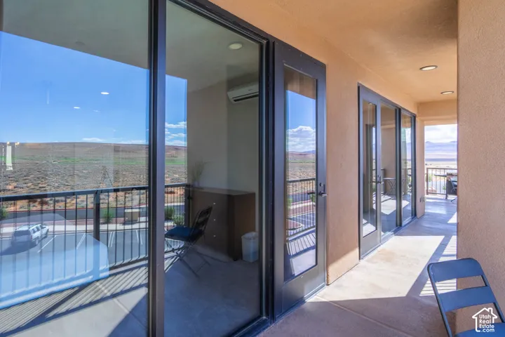 Private balcony featuring multiple glass panel doors, black metal railings, and recessed lighting