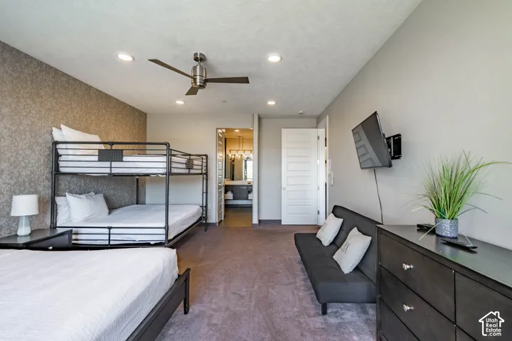 Feature wall with textured wallpaper, recessed lighting, and a ceiling fan
