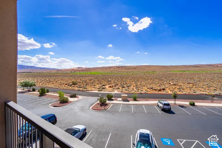 Expansive desert landscape with distant mountains, complemented by an on-site parking area and landscaped islands