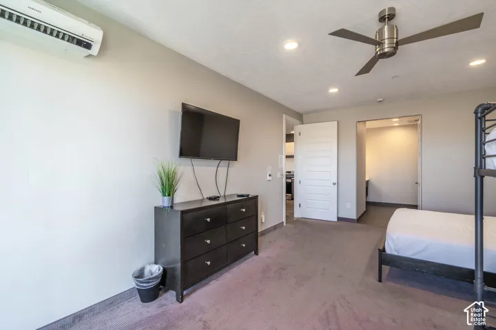 Wall-mounted air conditioning unit, recessed ceiling lighting, and a contemporary ceiling fan