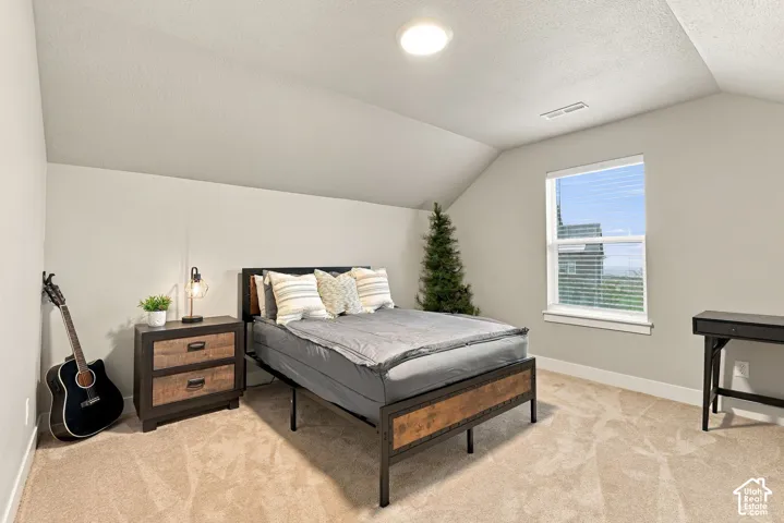 Attic bedroom with neutral carpeting and paint