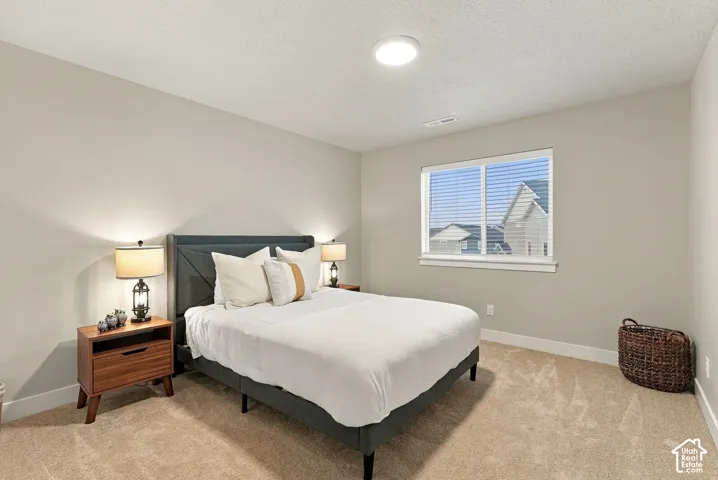 Neutral tone walls, carpet flooring, a window with blinds, and recessed lighting