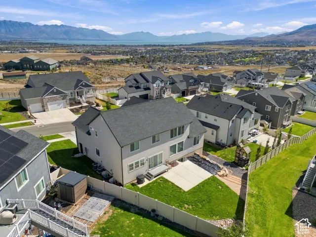 Contemporary residence with a multi-gabled roof, light-toned siding, and a rear concrete patio