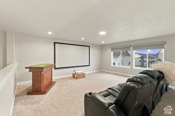 Recessed lighting, light-toned walls, and carpeted flooring