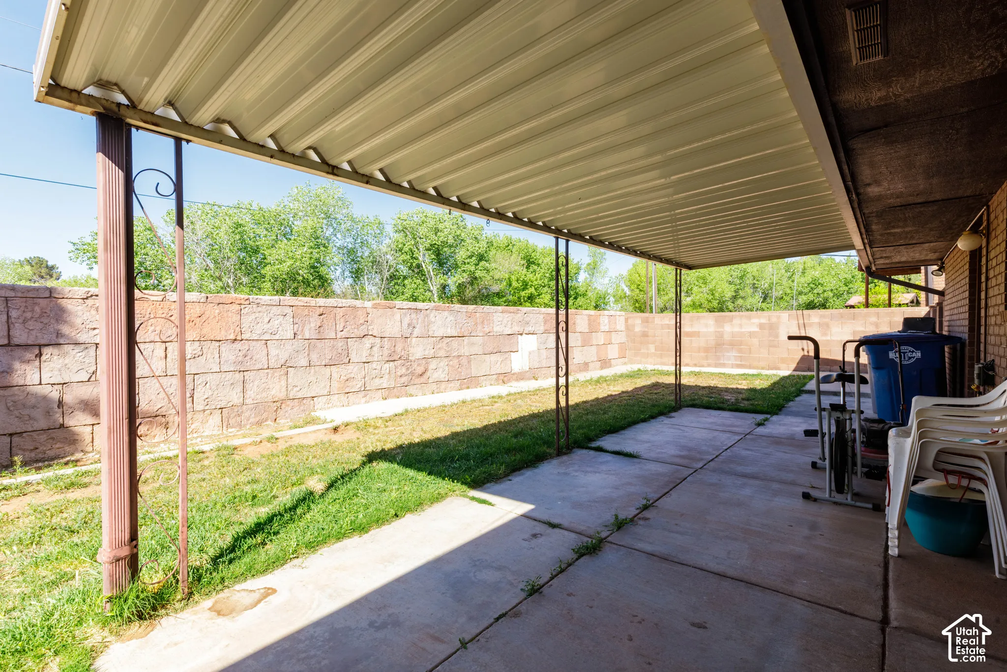 Covered patio featuring a concrete slab and metal supports