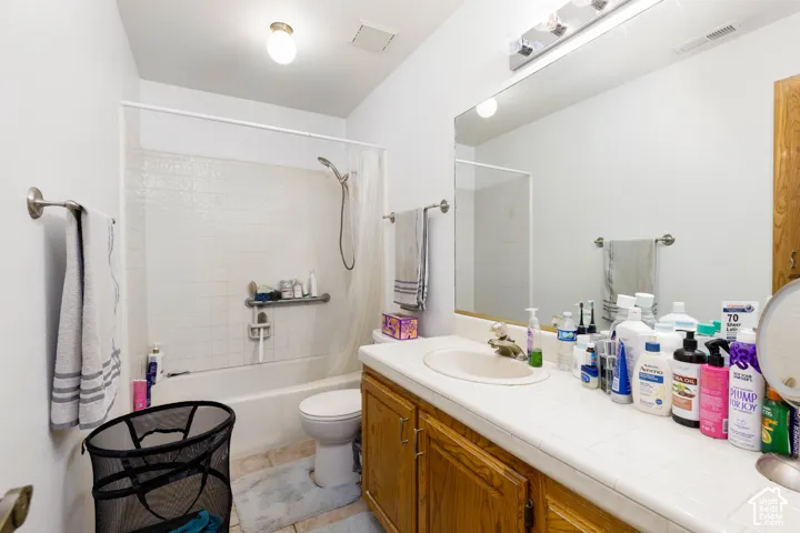 White tiled shower with a handheld showerhead