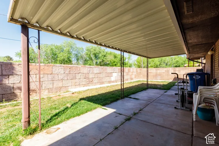 Covered patio featuring a concrete slab and metal supports