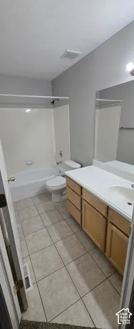 Bathroom featuring a vanity with light wood-finish cabinetry, a white countertop, and an integrated sink