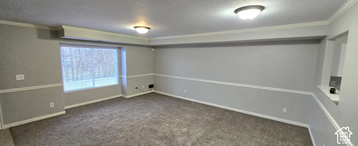 Room featuring neutral gray walls, crown molding, chair rail molding, and recessed window