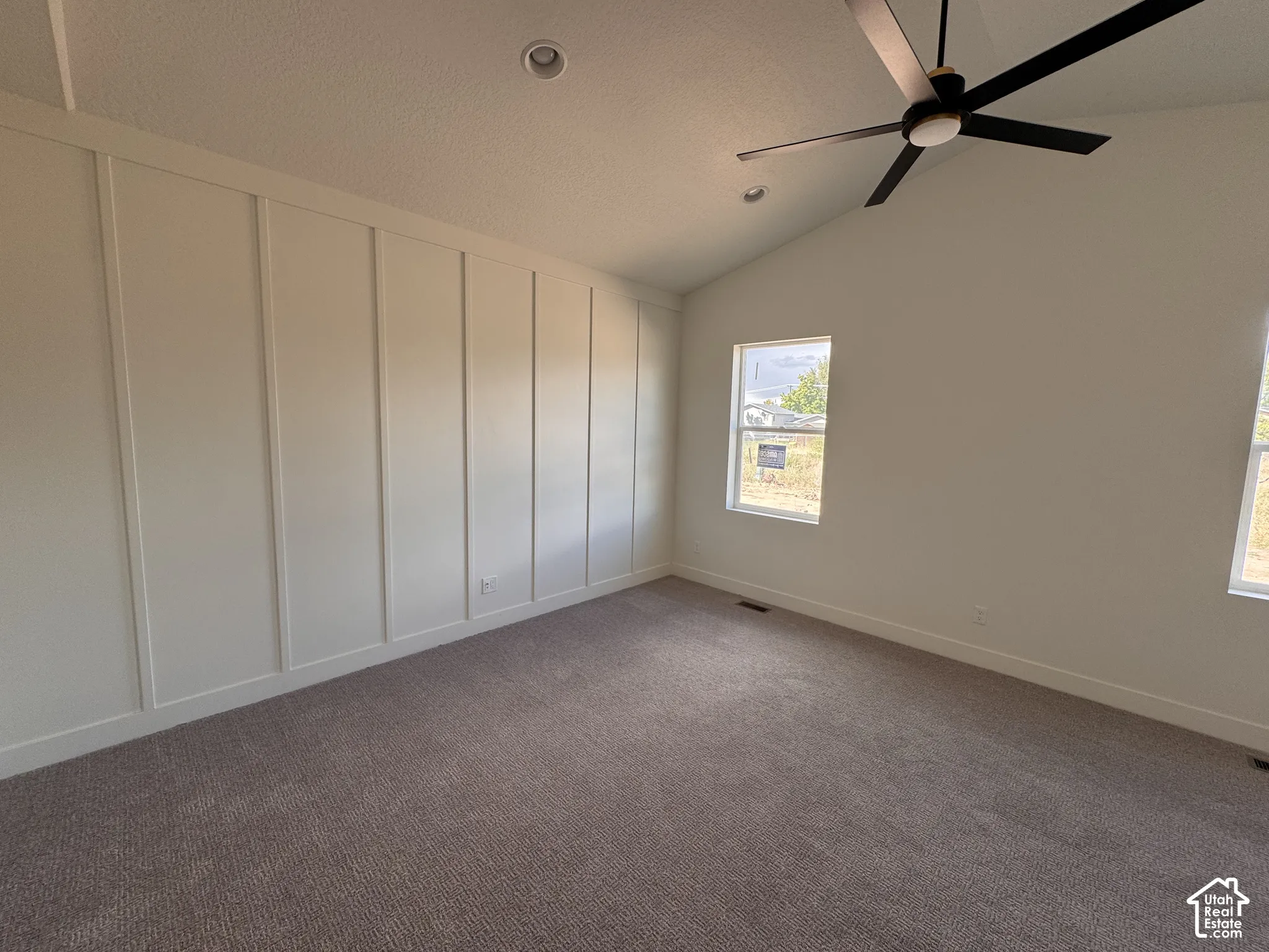 Spacious bedroom with neutral wall finishes, recessed ceiling lighting, and a modern ceiling fan