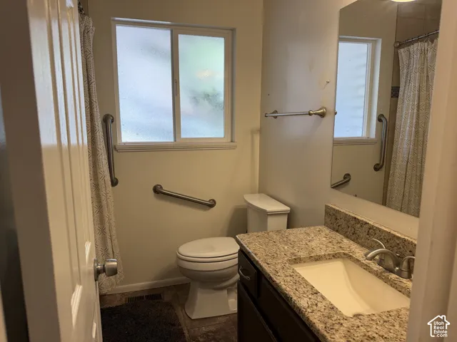 Bathroom featuring a vanity with a light-toned countertop, an undermount sink, and a framed mirror