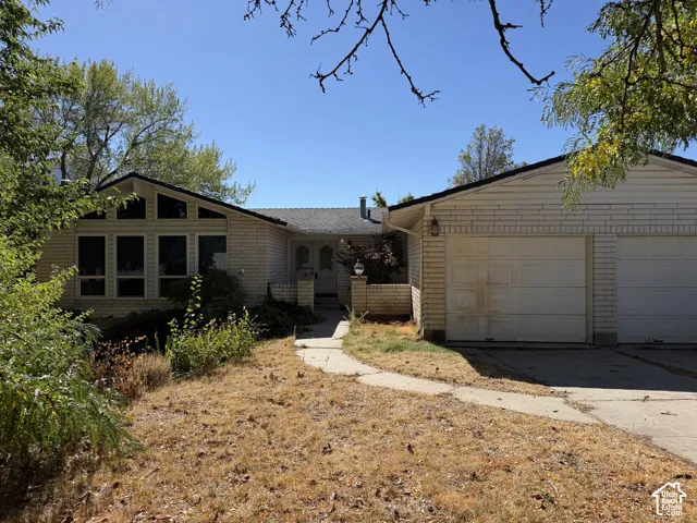 Attached two-car garage, brick exterior, front entry porch, and large picture windows