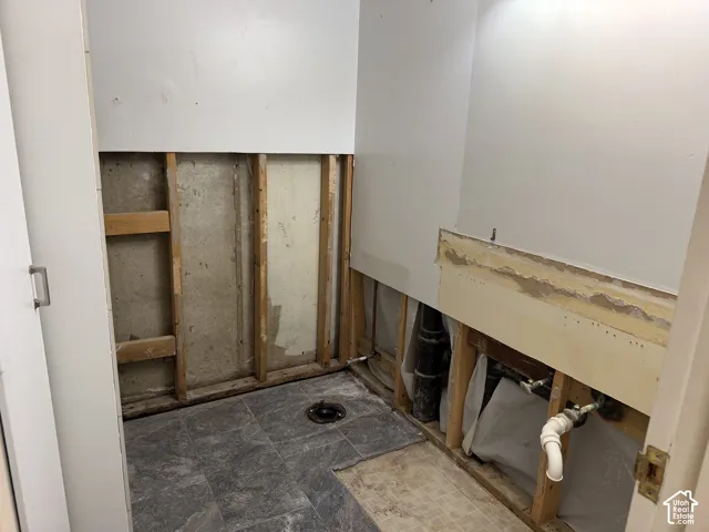 The toilet and vanity have been removed but remain in the property, stored in the adjacent room.