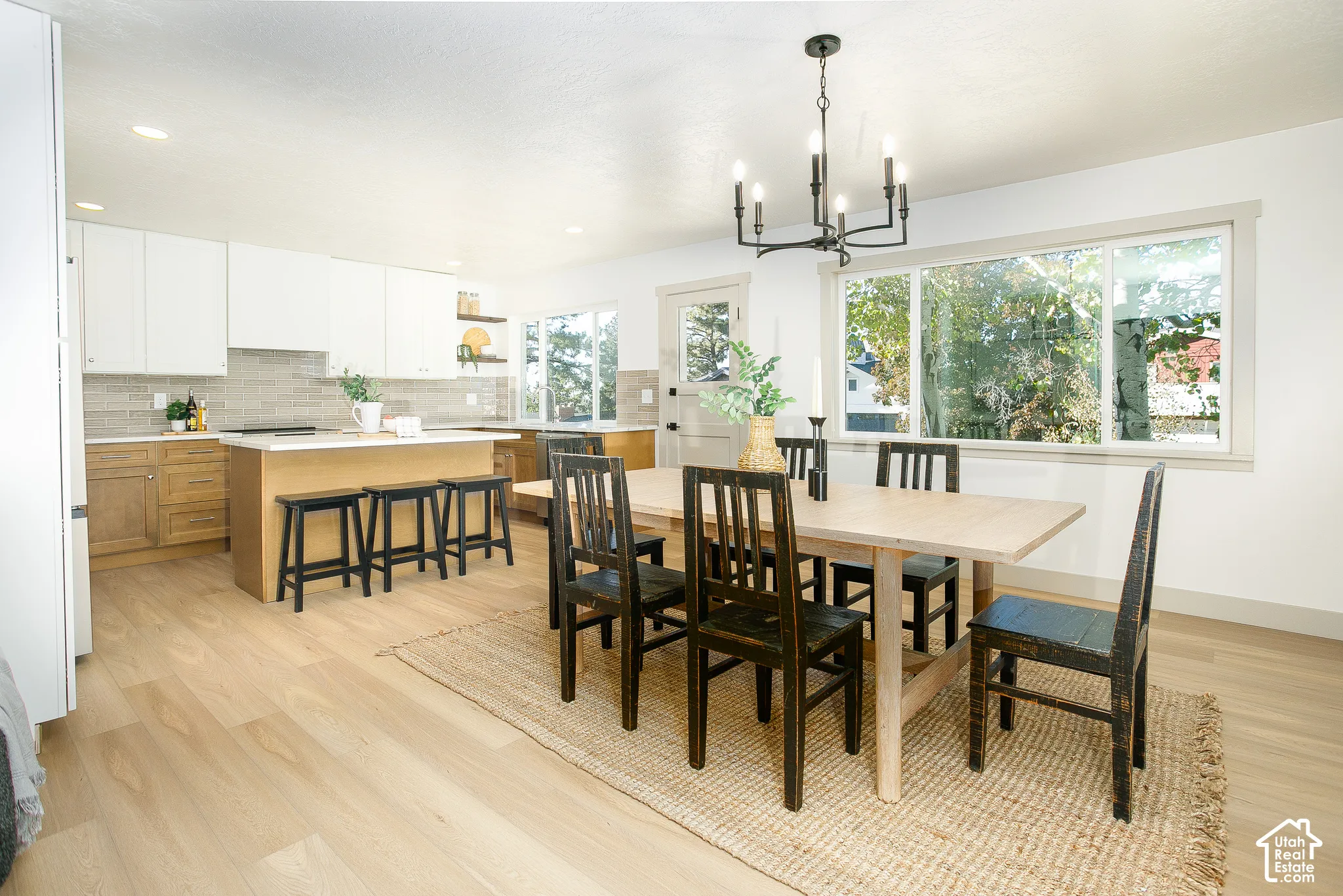 Open-concept kitchen and dining area featuring light-toned wood-finish flooring