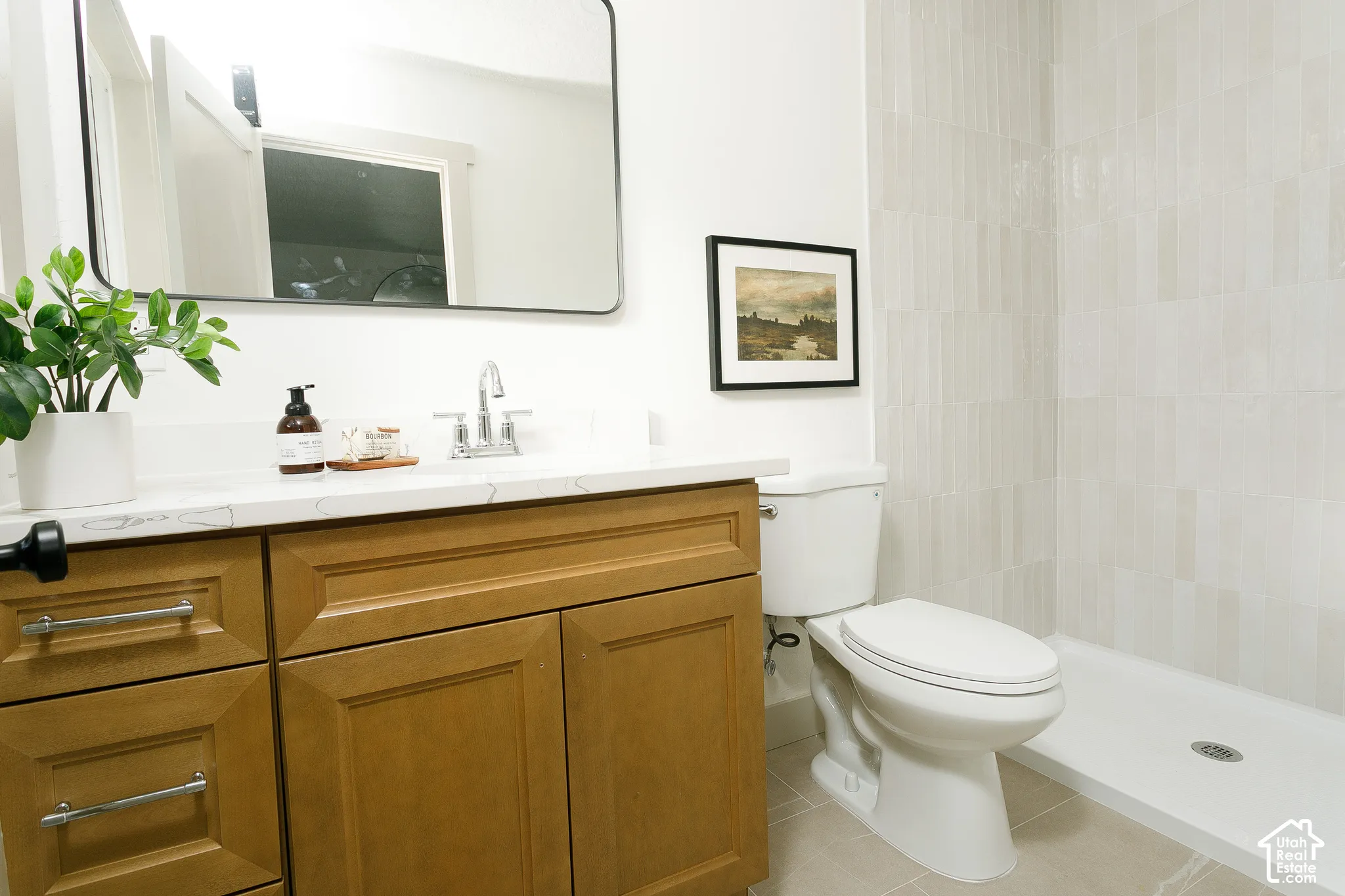 Wood-finish vanity with a light-toned countertop and chrome faucet