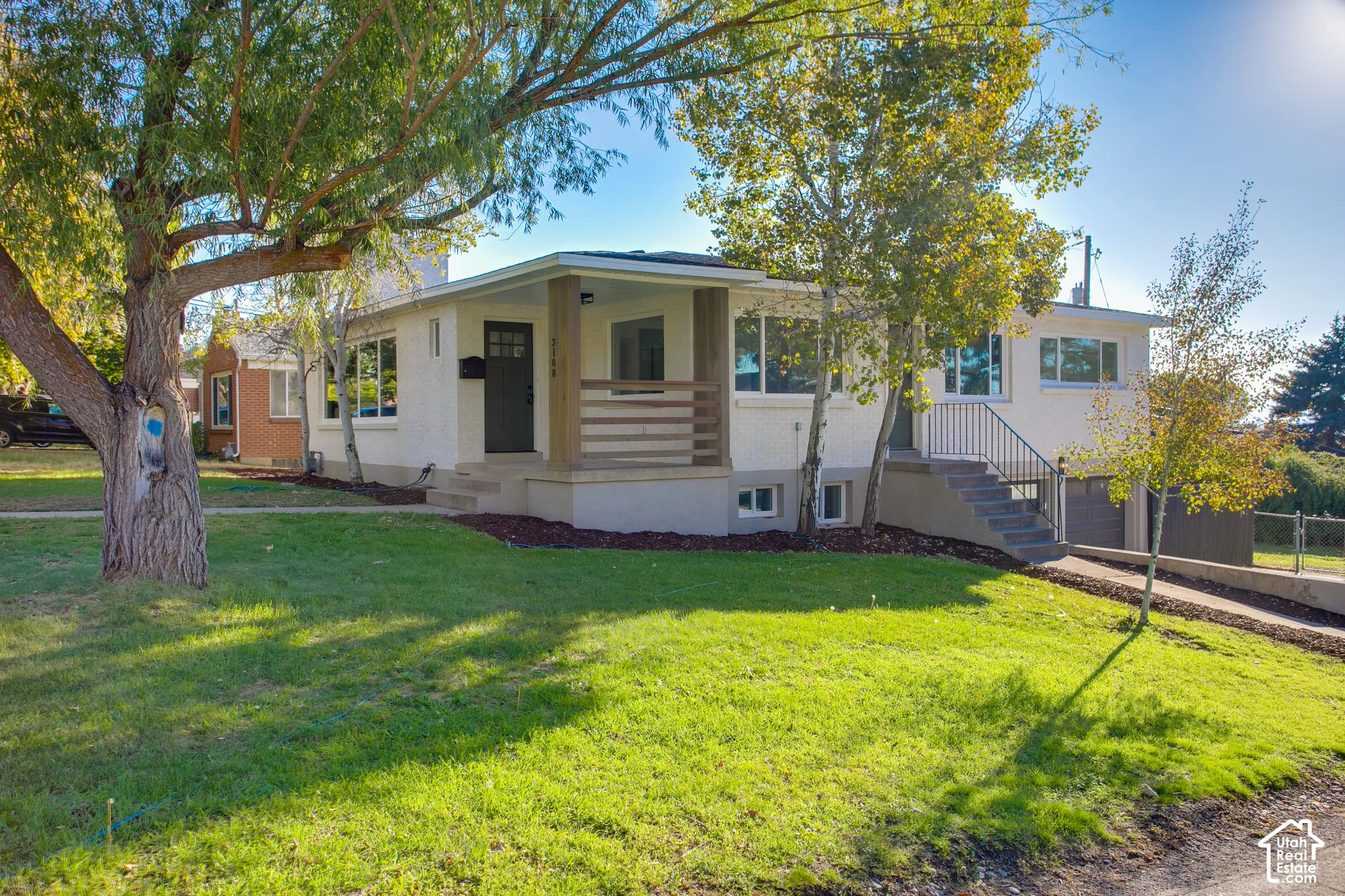 Front exterior featuring a covered entry, established landscaping, and a driveway leading to a built-in garage
