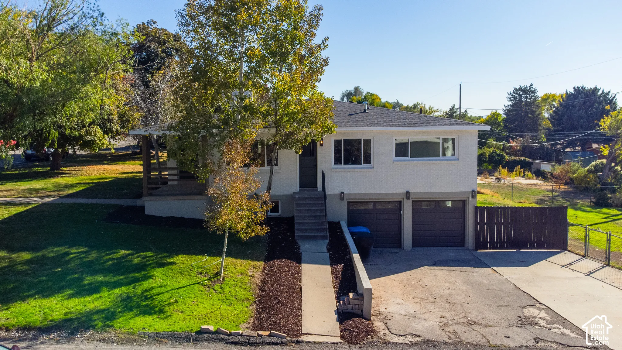 Two-story exterior with a two-car garage, front porch, and mature trees