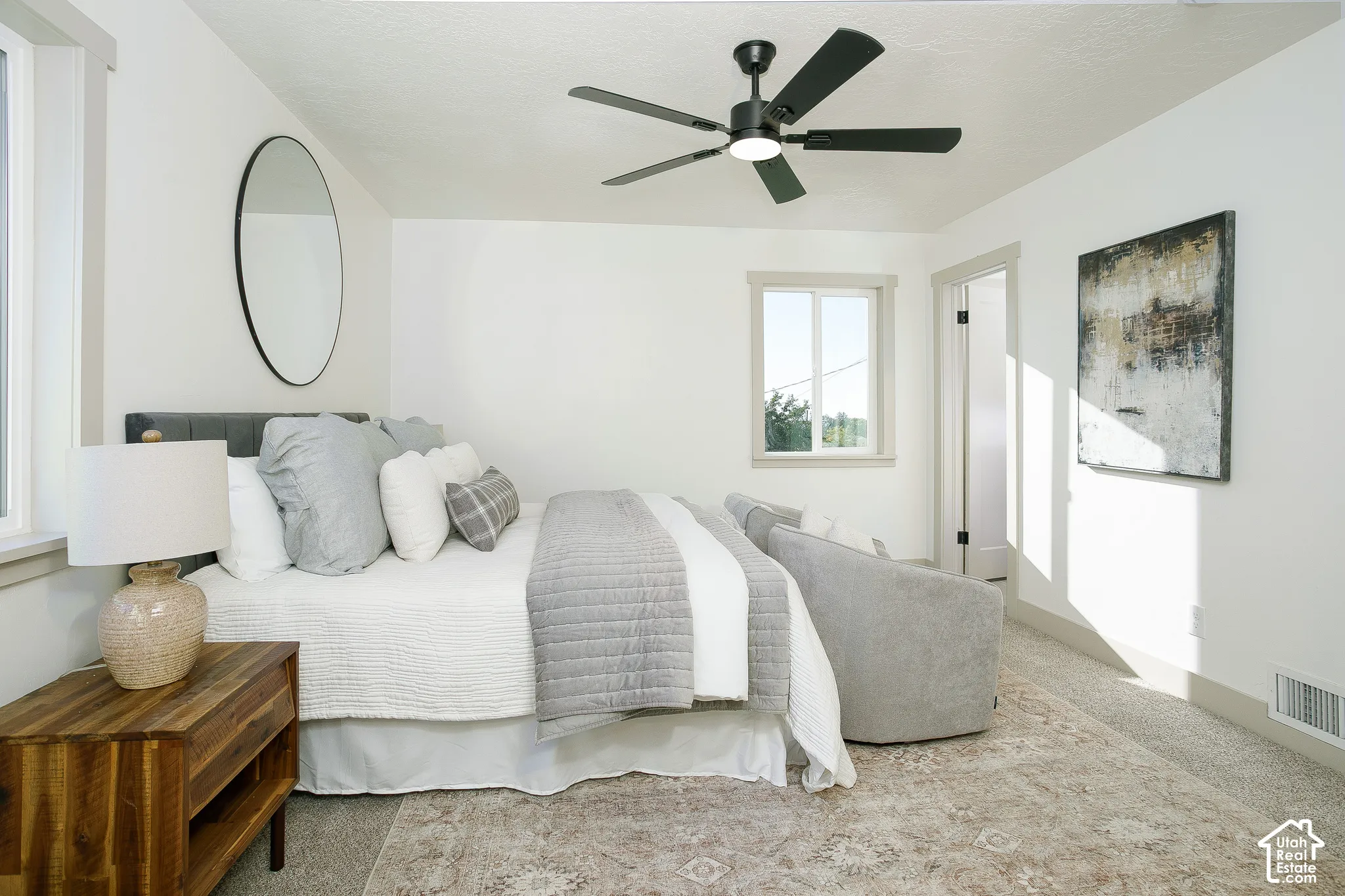 White walls featuring a black ceiling fan, recessed window, and light-toned carpet