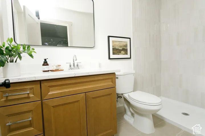 Wood-finish vanity with a light-toned countertop and chrome faucet