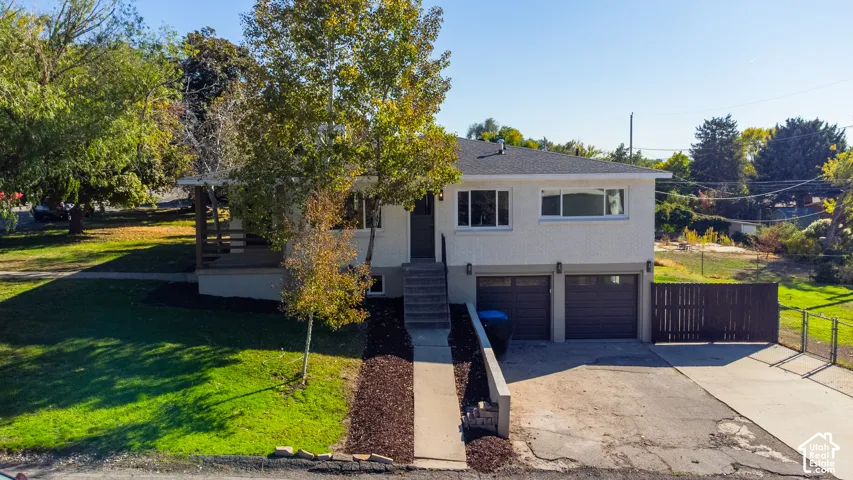 Two-story exterior with a two-car garage, front porch, and mature trees