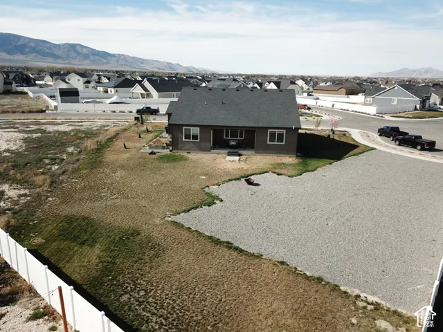 Rear exterior with a patio, stone-finish siding, and a gravel yard