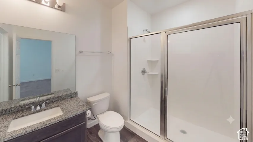 Bathroom featuring a vanity with granite-style countertop, integrated sink, and wood-finish cabinetry