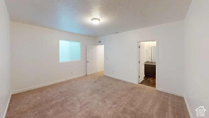 Neutral wall finishes, recessed window, wall-to-wall carpeting, bathroom access, overhead lighting