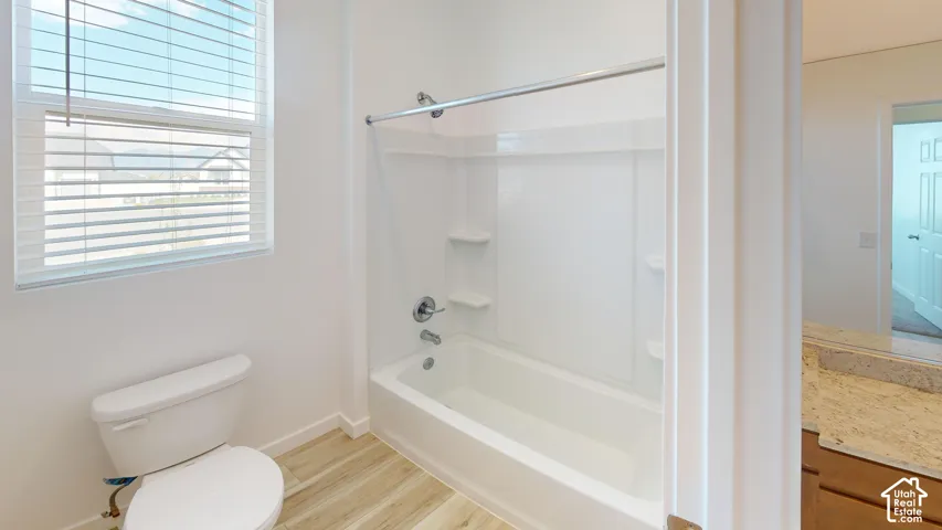 White bathtub with integrated shelving, chrome fixtures, and a shower rod