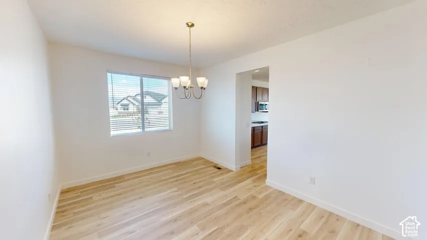 Light wood-finish flooring with a modern four-light chandelier