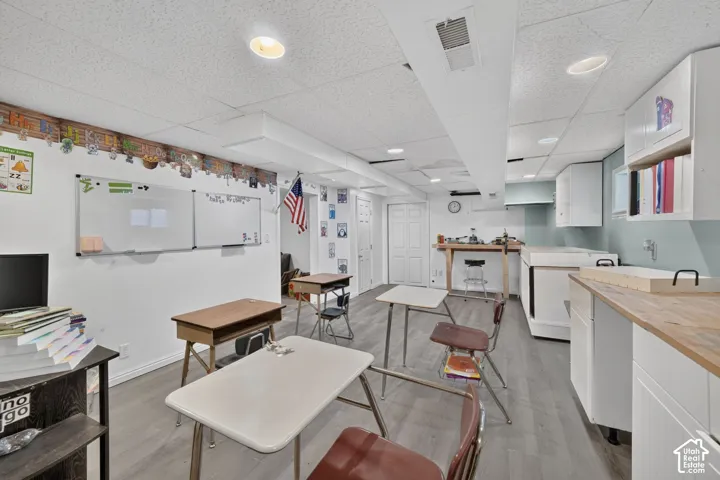 Recessed lighting, wood-finish flooring, white walls, and built-in cabinetry with wood-finish countertops