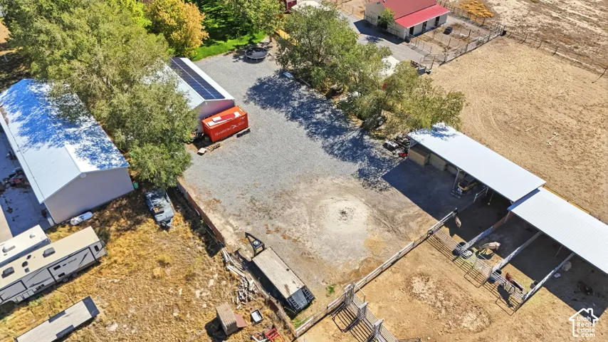 Multiple outbuildings with metal roofs, solar panels, and fenced animal enclosures