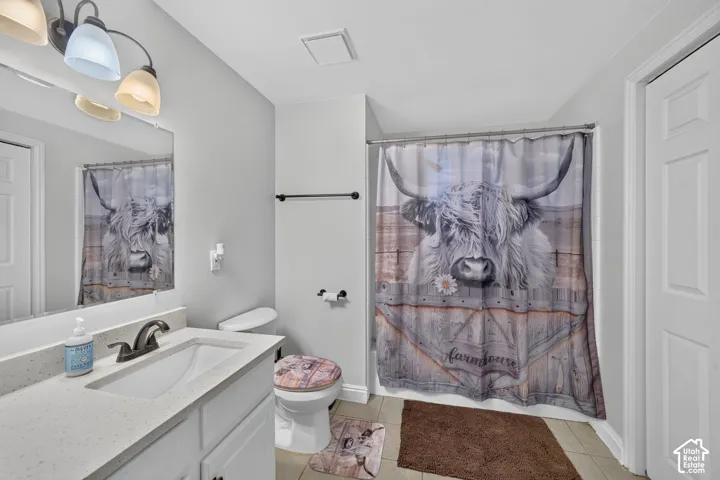 White vanity with a light-colored countertop, undermount sink, and dark-finish faucet