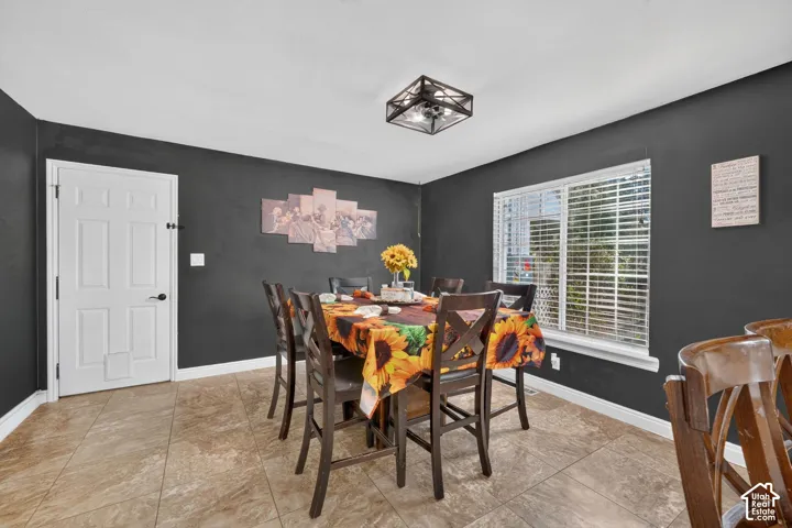 Tile flooring, white trim, single window, white paneled door, and a black ceiling fan fixture