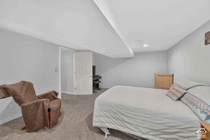 Neutral gray wall paint, recessed lighting, white interior doors, and carpet flooring