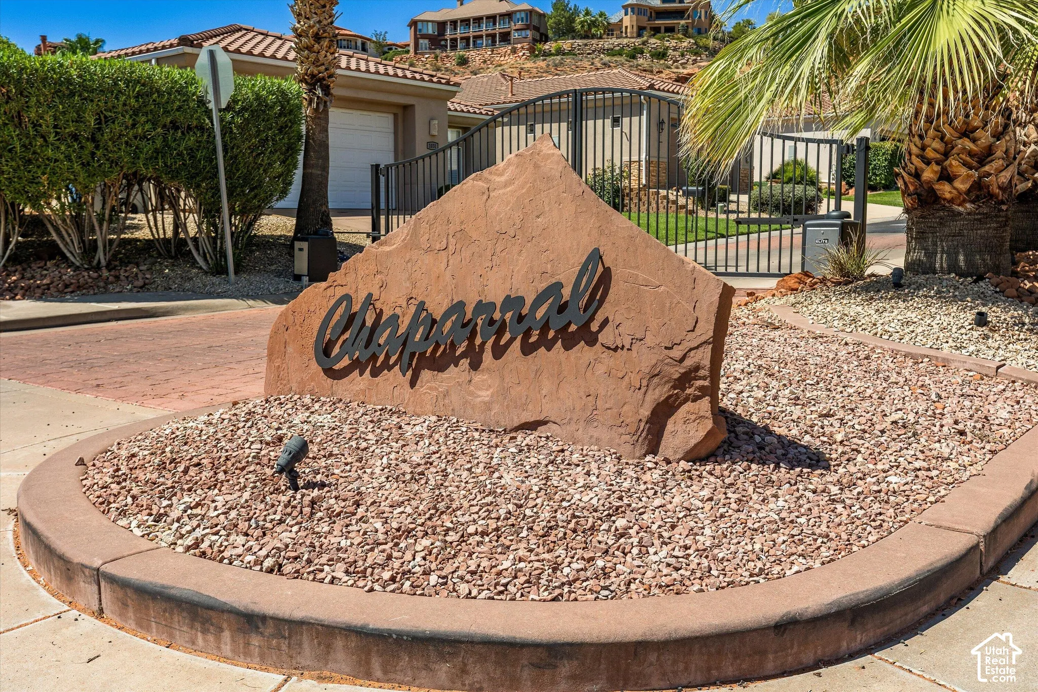 Custom stone entry monument featuring raised lettering, integrated landscaping, and a paver drive