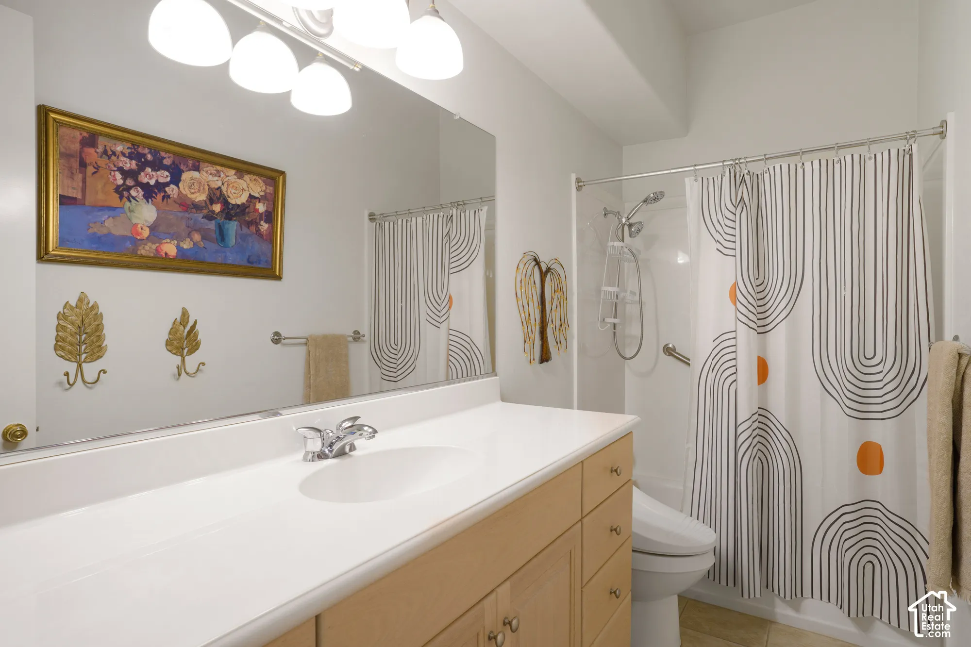 White countertop with an integrated sink, chrome faucet, and light wood-finish cabinetry