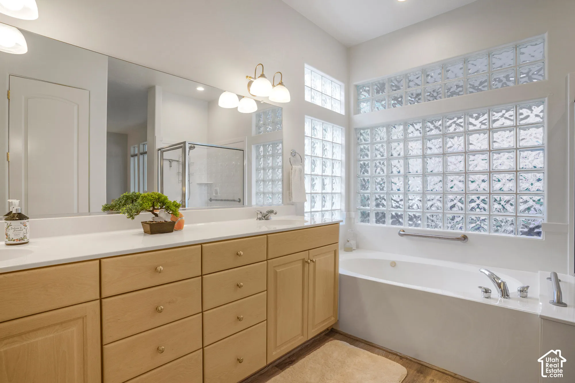 Dual vanity with light wood-finish cabinetry and white countertops