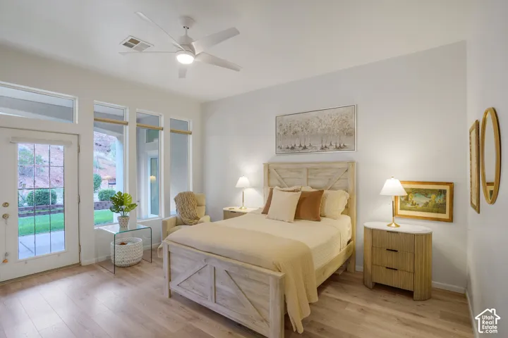 Wood-finish flooring with white walls and a ceiling fan