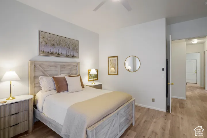 Wood-finish flooring, ceiling fan, and light-toned walls