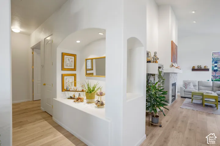 Arched entryway with recessed lighting and wood-finish flooring